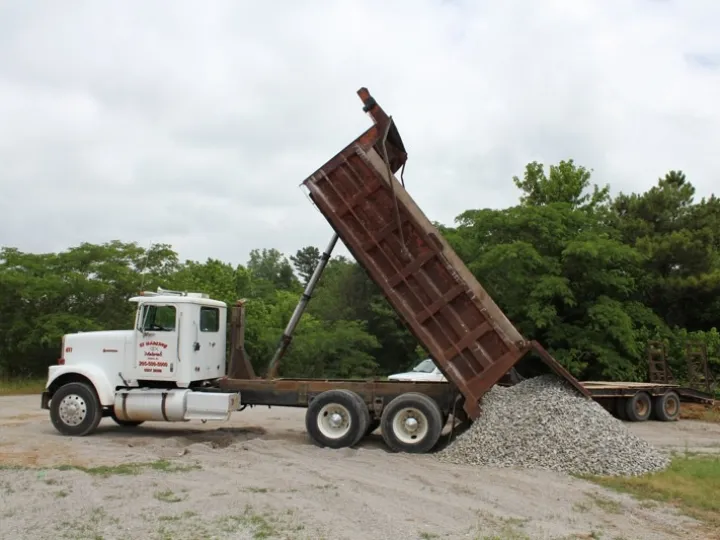 CT Hauling dump truck tipping a load of crushed stone in Central Alabama