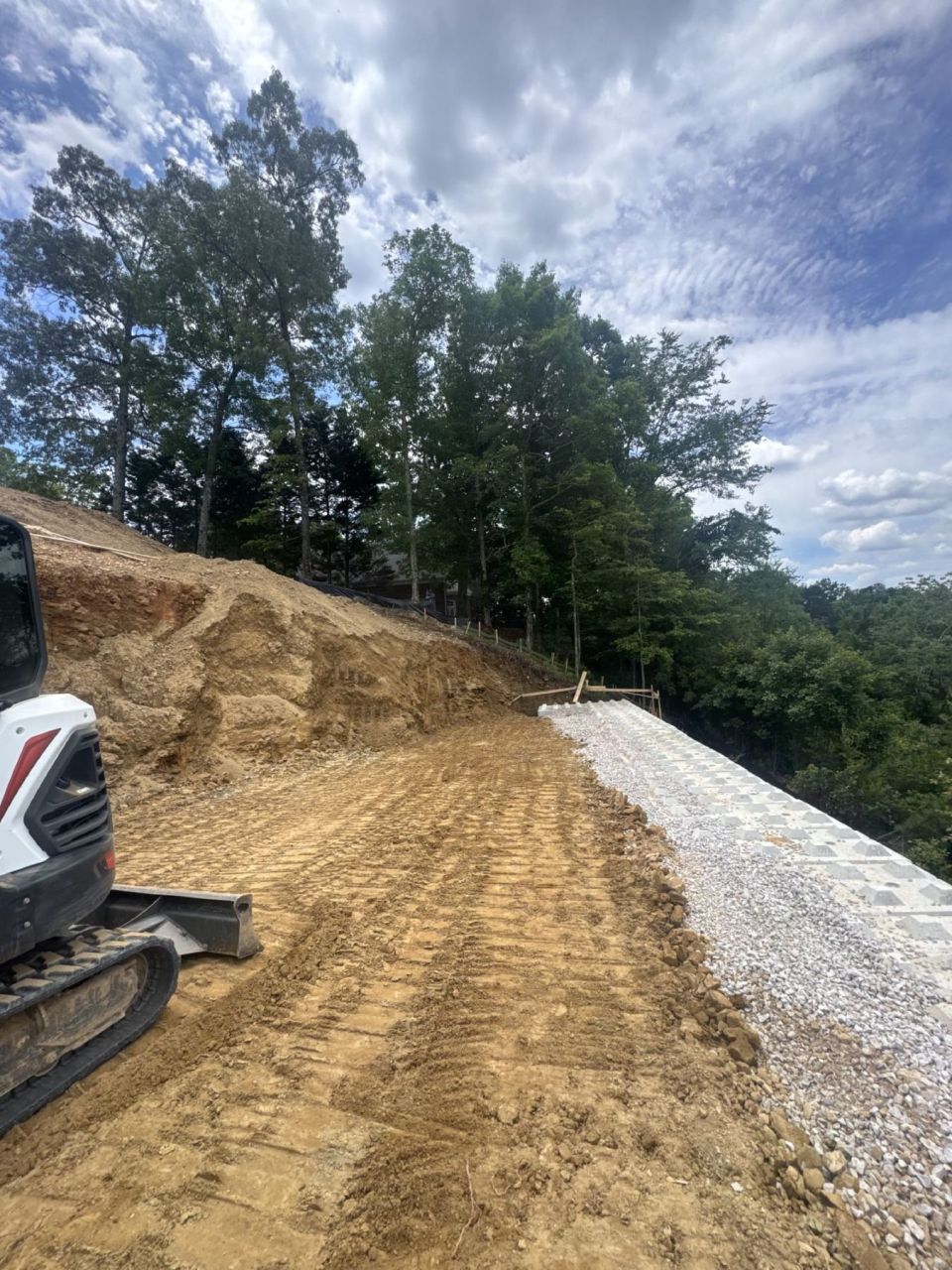 Graded backfill with a strip of drainage stone along the top of a new concrete block wall